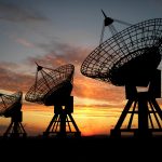 Three satelite dishes over sunset